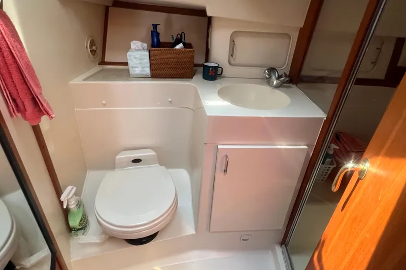 Slide: The Image of Bathroom interior of 2001 Mainship 390 Trawler with sink, toilet, and storage. - 17