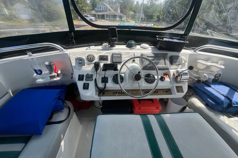 Slide: The Image of 2001 Mainship 390 Trawler helm with steering wheel, navigation instruments, and seating area. - 28