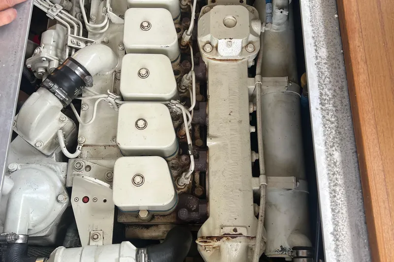 Slide: The Image of Engine compartment of a 2001 Mainship 390 Trawler, showcasing mechanical components and piping. - 38