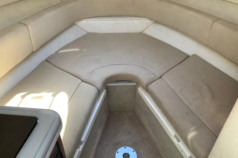 Slide: The Image of 2013 Sea Ray 240 Sundancer cabin interior with beige seating and compact design. - 11