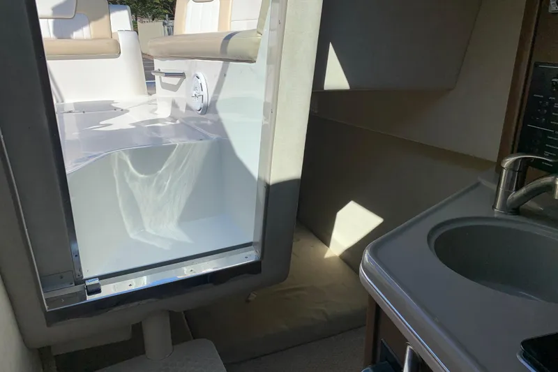 Slide: The Image of Interior view of 2013 Sea Ray 240 Sundancer boat, featuring seating and a compact sink area. - 13