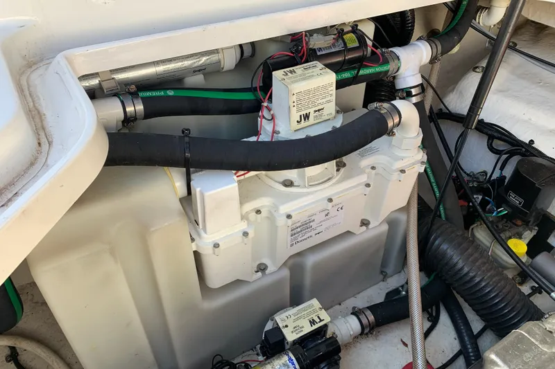 Slide: The Image of Engine compartment of a 2013 Sea Ray 240 Sundancer boat, showing mechanical components and hoses. - 18