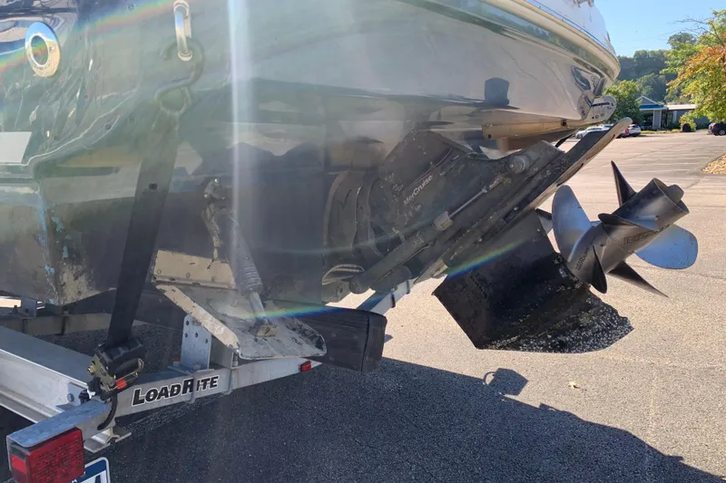 Slide: The Image of 2013 Sea Ray 240 Sundancer boat on trailer, showing propeller and stern drive. - 19