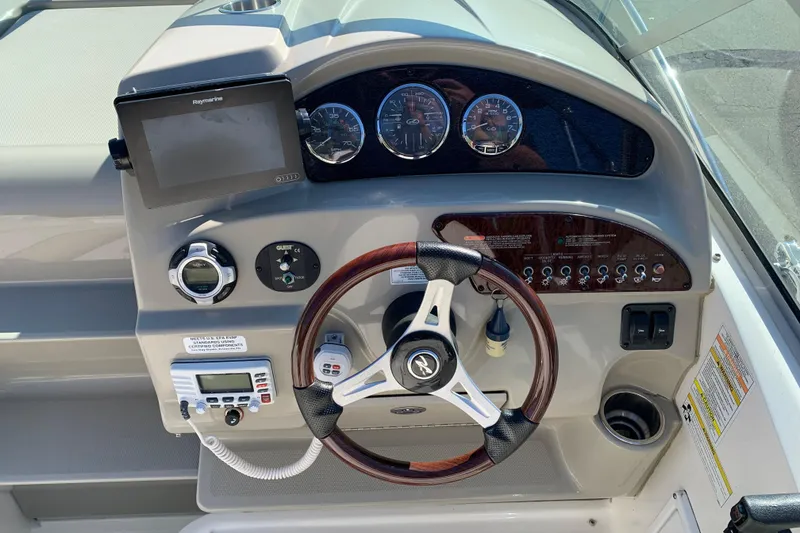 Slide: The Image of 2013 Sea Ray 240 Sundancer dashboard with steering wheel, gauges, and navigation system. - 4