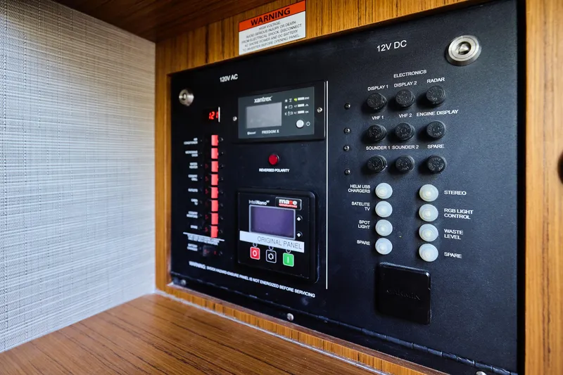 Slide: The Image of Electrical control panel of 2022 Solace 41 CS boat, featuring various switches and displays. - 18