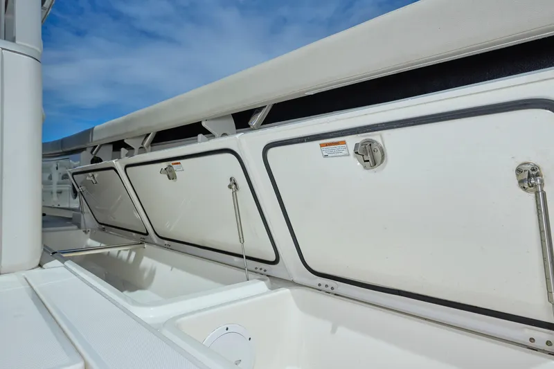 Slide: The Image of 2022 Solace 41 CS boat storage compartments with open hatches under a clear blue sky. - 24