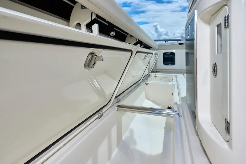 Slide: The Image of 2022 Solace 41 CS boat interior storage compartments under a clear blue sky. - 28