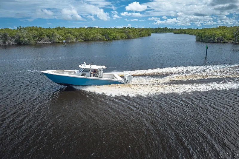 Slide: The Image of 2022 Solace 41 CS boat cruising on a scenic river under a blue sky. - 4