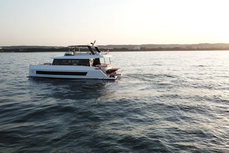 Slide: The Image of Luxury Moon Yachts 6ty 2026 sailing at sunset on calm waters. - 22