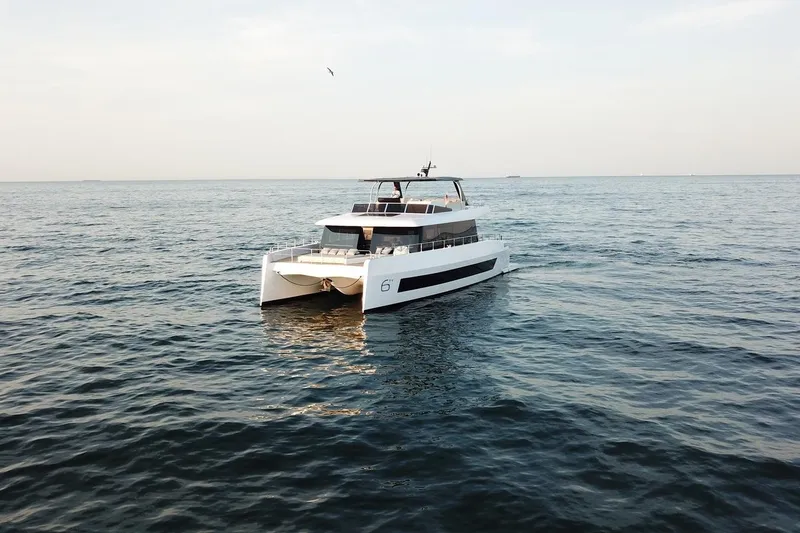 Slide: The Image of 2026 Moon Yachts 6ty catamaran sailing on open sea under clear sky. - 37
