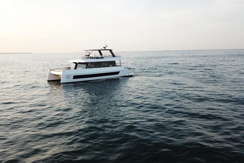 Slide: The Image of 2026 Moon Yachts 6ty sailing on calm ocean waters at sunset. - 43