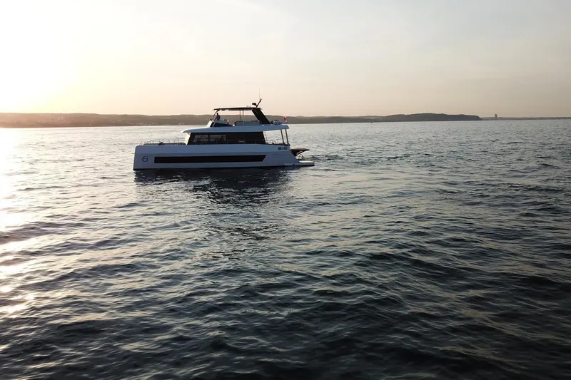 Slide: The Image of 2026 Moon Yachts 6ty sailing at sunset on calm waters. - 50