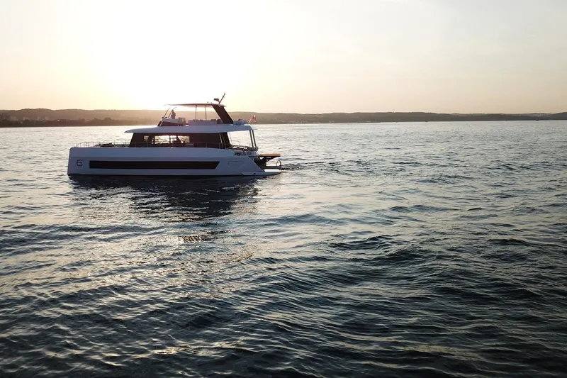 Slide: The Image of 2026 Moon Yachts 6ty sailing at sunset on calm waters. - 53