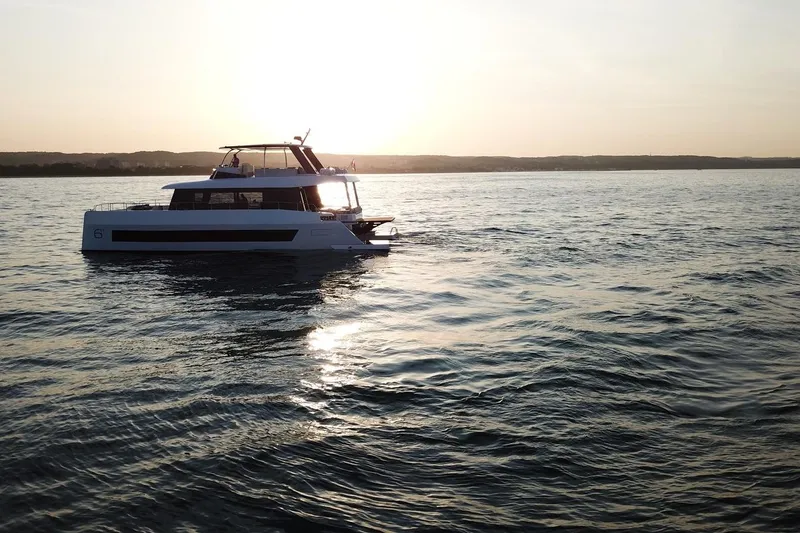 Slide: The Image of 2026 Moon Yachts 6ty sailing at sunset on calm waters. - 54