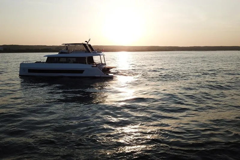 Slide: The Image of 2026 Moon Yachts 6ty sailing at sunset on calm waters. - 55