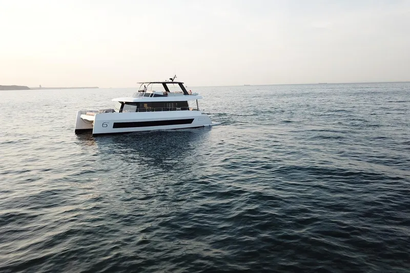 Slide: The Image of 2026 Moon Yachts 6ty sailing on calm ocean waters at sunset. - 44