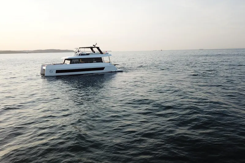 Slide: The Image of Luxurious 2026 Moon Yachts 6ty catamaran cruising on serene ocean waters at sunset. - 46