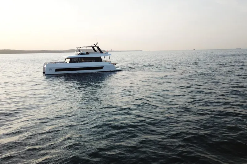 Slide: The Image of 2026 Moon Yachts 6ty sailing on calm waters at sunset. - 47