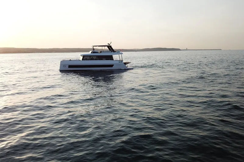 Slide: The Image of 2026 Moon Yachts 6ty sailing on calm waters at sunset. - 49