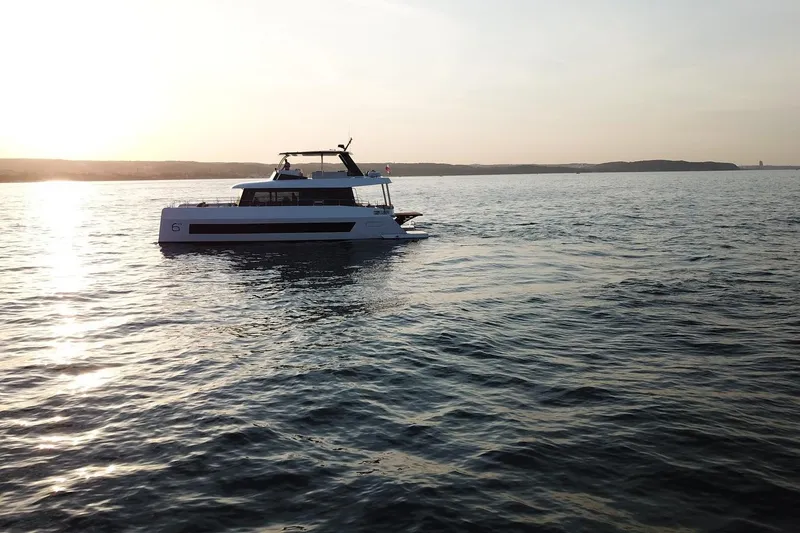 Slide: The Image of 2026 Moon Yachts 6ty sailing at sunset on calm waters. - 51