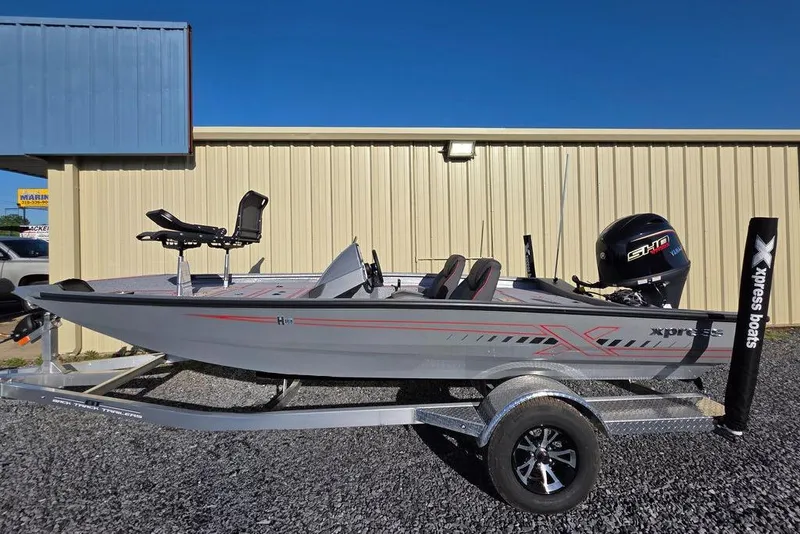 Slide: The Image of 2025 Xpress H18C Crappie boat on trailer, parked outside a building. - 17