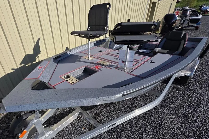 Slide: The Image of 2025 Xpress H18C Crappie fishing boat with seating and storage, parked on gravel. - 3