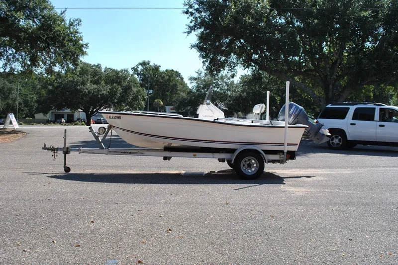 Slide: The Image of 2003 Cape Craft 16 boat on trailer in parking lot, surrounded by trees. - 1