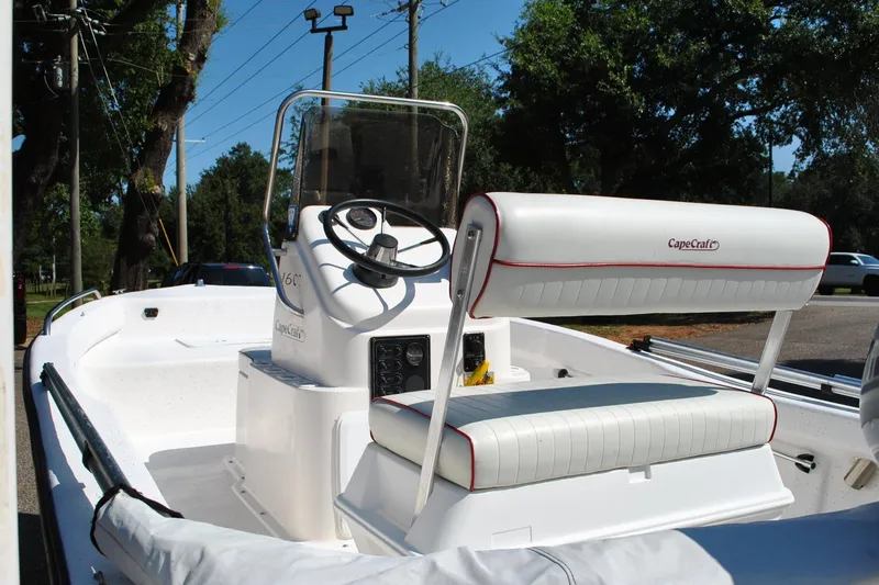 Slide: The Image of 2003 Cape Craft 16 boat interior with steering console and seating, parked outdoors. - 18