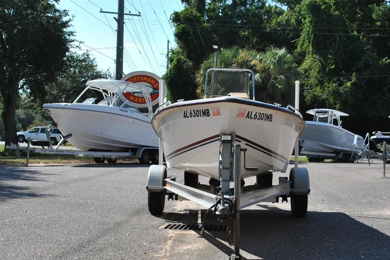 Slide: The Image of 2003 Cape Craft 16 boat on trailer at marina, surrounded by trees and other boats. - 4