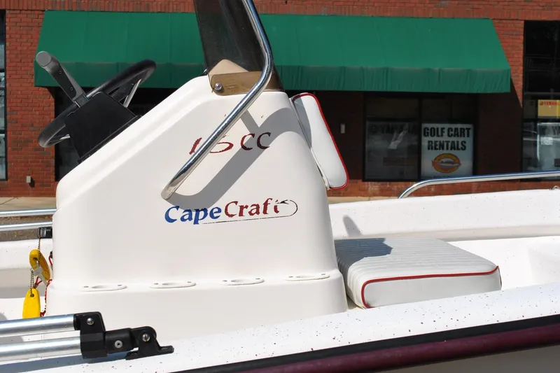 Slide: The Image of 2003 Cape Craft 16 boat console with steering wheel, parked near a brick building. - 7