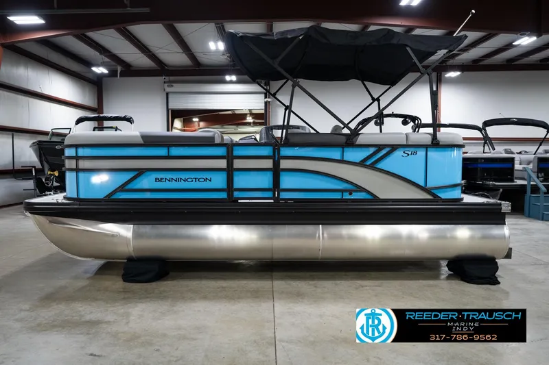 Slide: The Image of 2026 Bennington 188 SL pontoon boat in showroom, featuring sleek blue design and canopy. - 10