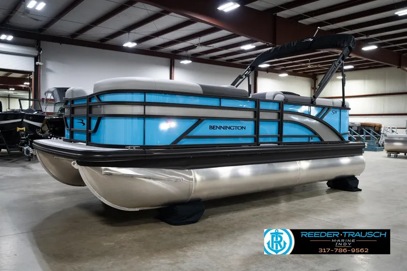 Slide: The Image of 2026 Bennington 188 SL pontoon boat in showroom, featuring sleek blue design and modern amenities. - 2