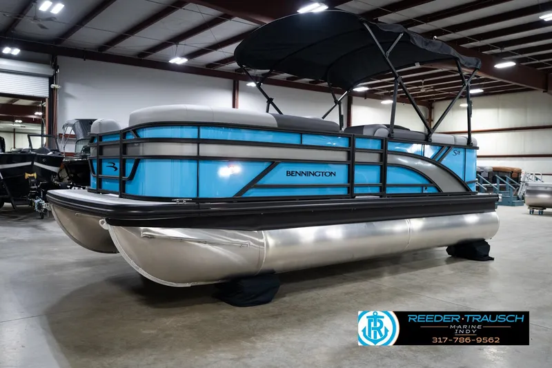 Slide: The Image of 2026 Bennington 188 SL pontoon boat in showroom, featuring sleek blue design and canopy. - 3