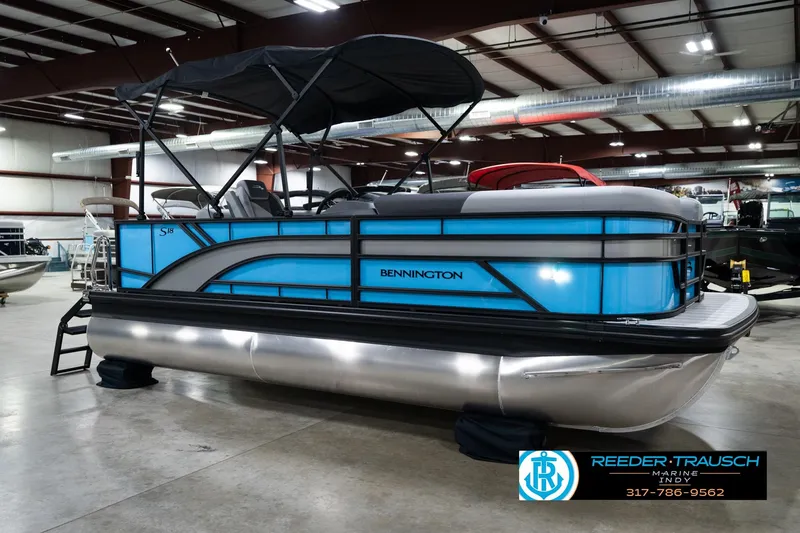 Slide: The Image of 2026 Bennington 188 SL pontoon boat in showroom, featuring sleek blue design and canopy. - 5