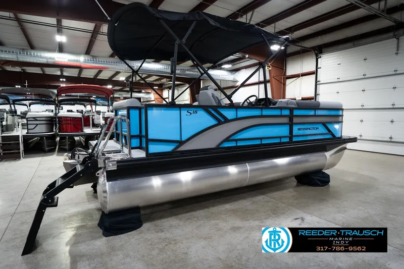 Slide: The Image of 2026 Bennington 188 SL pontoon boat in showroom, featuring sleek blue design and canopy. - 7