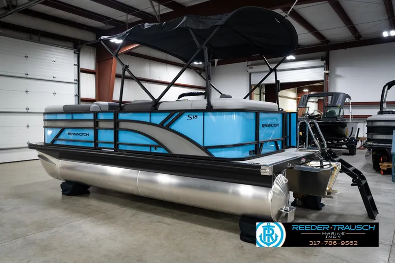 Slide: The Image of 2026 Bennington 188 SL pontoon boat in showroom, featuring sleek blue design and canopy. - 9