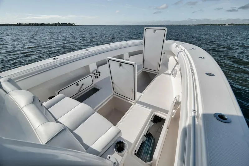 Slide: The Image of 2018 Invincible 36' Open Fisherman boat interior with open storage compartments on calm water. - 17