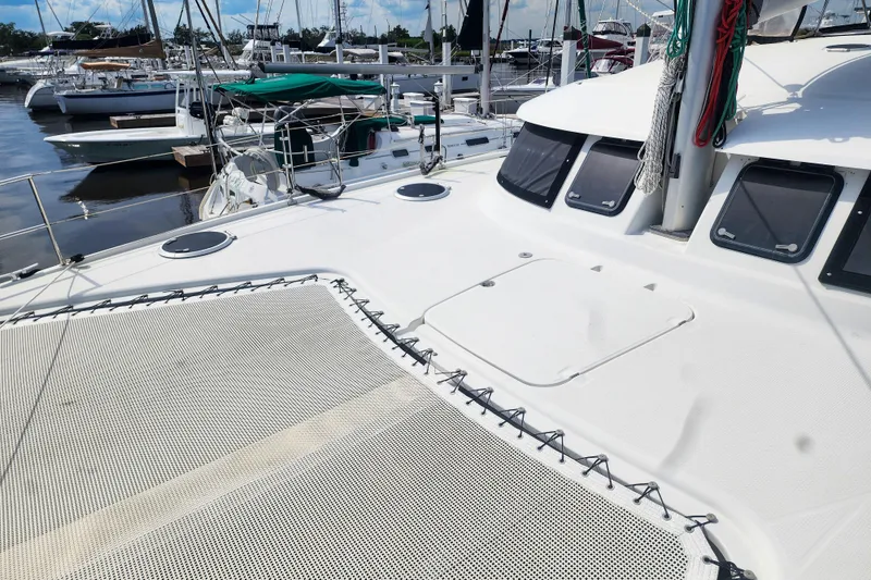Slide: The Image of 2013 Fountaine Pajot Lipari 41 catamaran docked at a marina, showcasing deck and netting. - 12