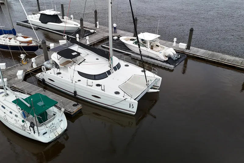 Slide: The Image of 2013 Fountaine Pajot Lipari 41 catamaran docked at marina with other boats. - 2