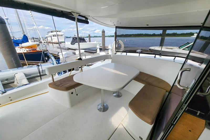 Slide: The Image of 2013 Fountaine Pajot Lipari 41 catamaran cockpit with seating and table, docked at marina. - 31