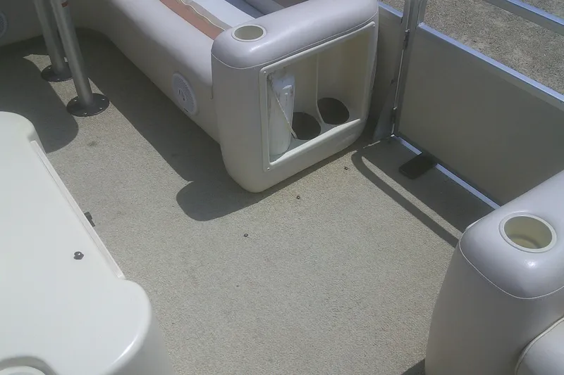 Slide: The Image of Interior of a 1999 Premier 250 Grand Majestic pontoon boat with seating and cup holders. - 11
