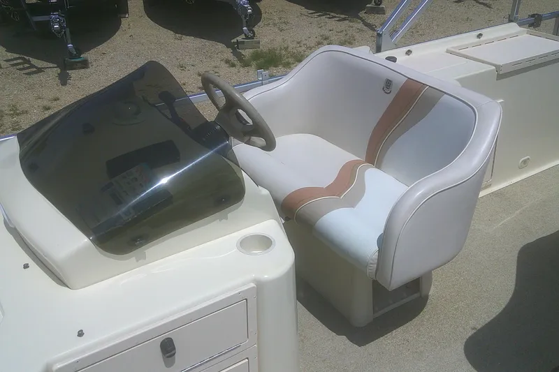Slide: The Image of 1999 Premier 250 Grand Majestic boat helm with cushioned captain's chair and steering wheel. - 13