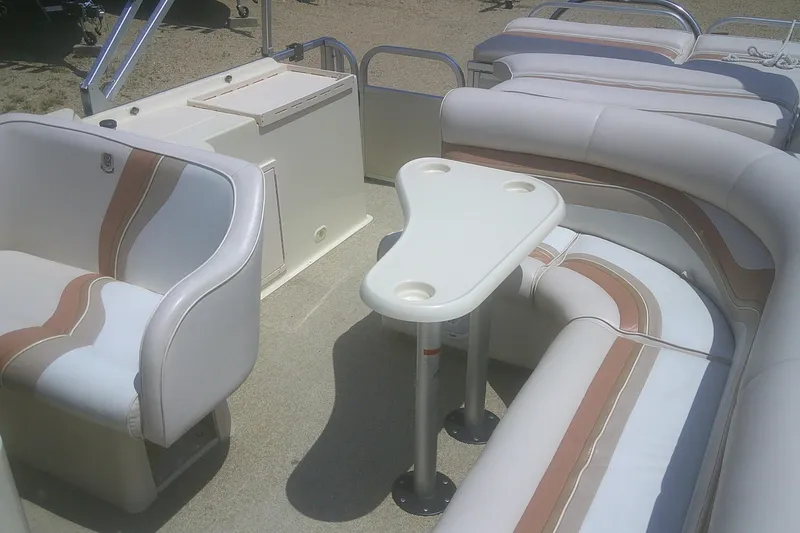 Slide: The Image of Interior of a 1999 Premier 250 Grand Majestic pontoon boat with seating and table. - 14