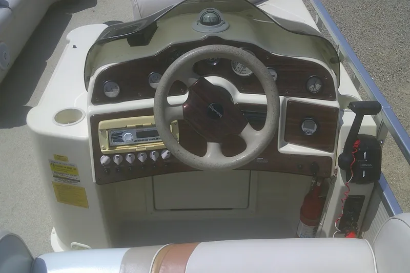 Slide: The Image of 1999 Premier 250 Grand Majestic boat dashboard with steering wheel and control panel. - 16