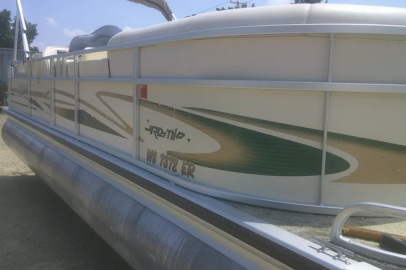 Slide: The Image of 1999 Premier 250 Grand Majestic pontoon boat with green and beige design, docked outdoors. - 26