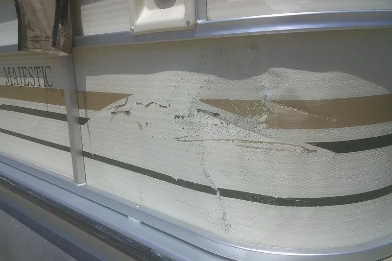 Slide: The Image of Damaged side panel of 1999 Premier 250 Grand Majestic boat with visible scratches and dents. - 3