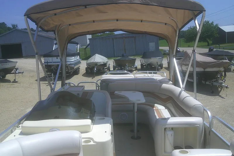 Slide: The Image of 1999 Premier 250 Grand Majestic pontoon boat with canopy and seating, parked outdoors. - 8
