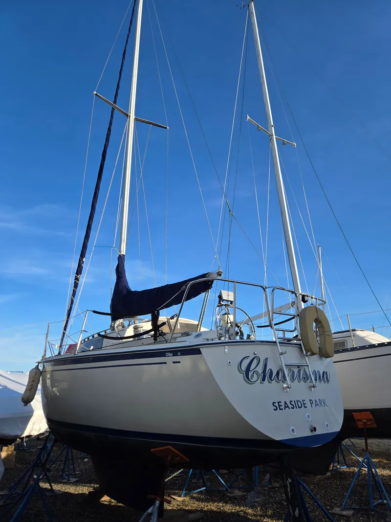 Slide: The Image of 1984 O'Day 30 sailboat on stands, named "Charisma," under clear blue sky. - 2