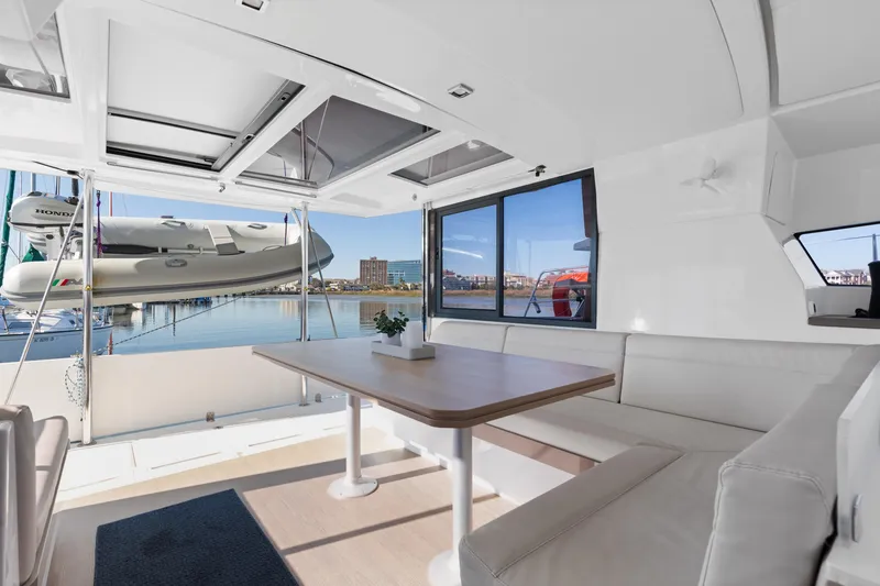 Slide: The Image of Spacious interior of 2018 Bali 4.0 catamaran with seating and table, overlooking marina. - 11