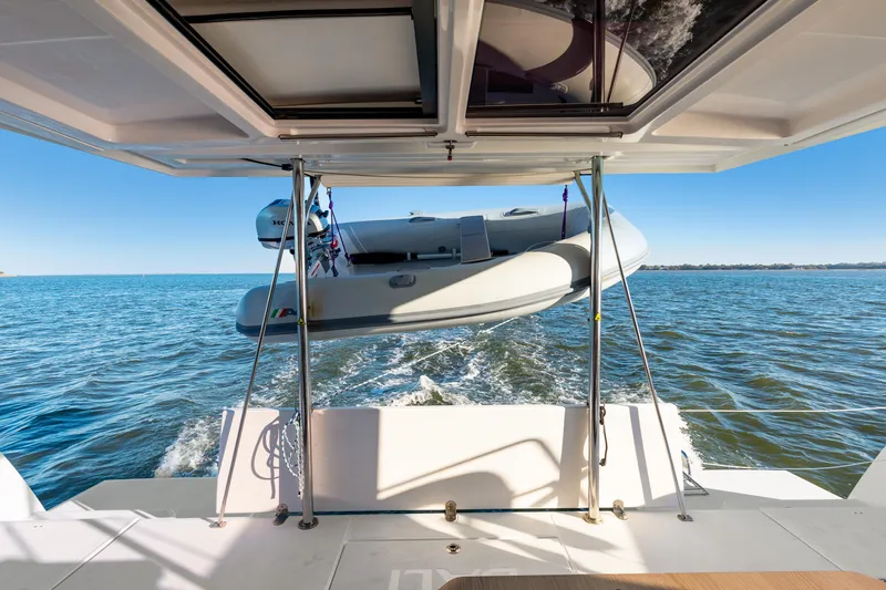 Slide: The Image of Bali 4.0 catamaran with dinghy on ocean, 2018 model, rear view. - 33